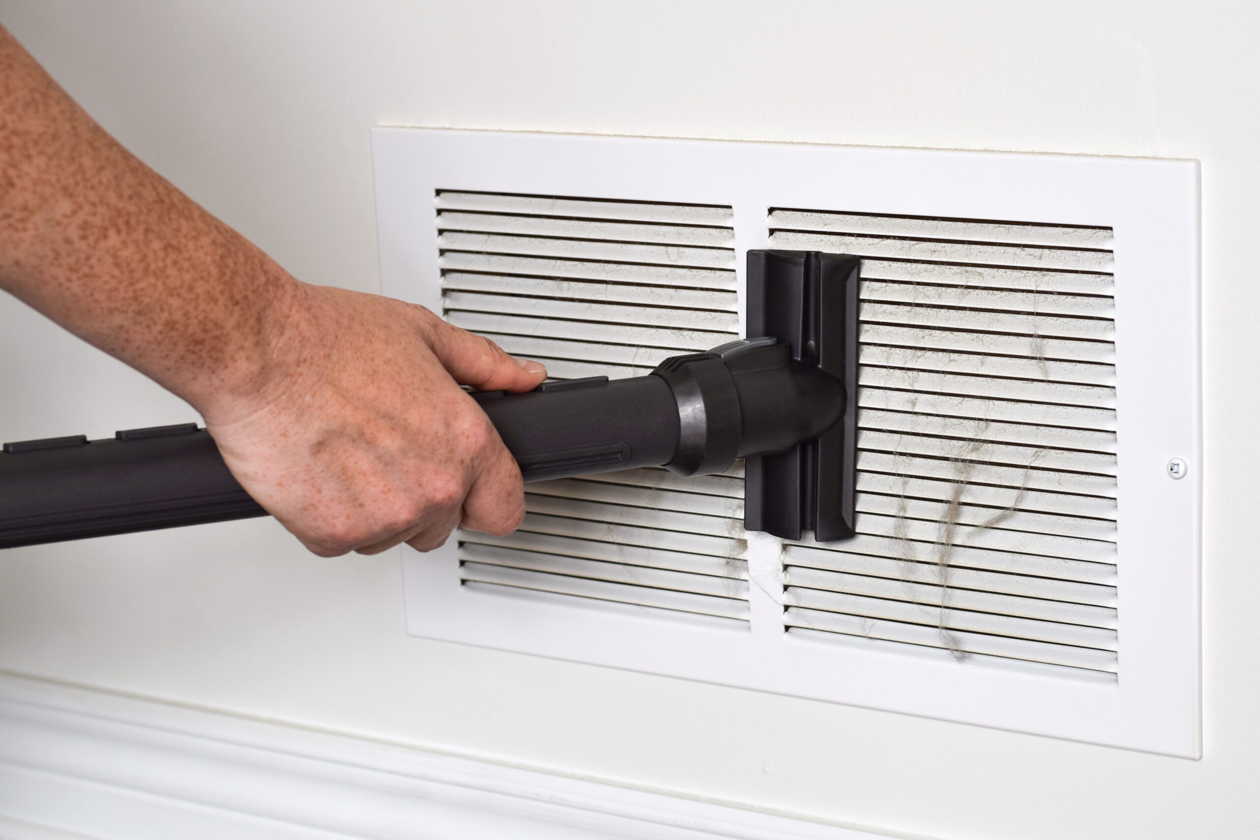 HVAC technician performing air duct cleaning inside a residential ventilation system