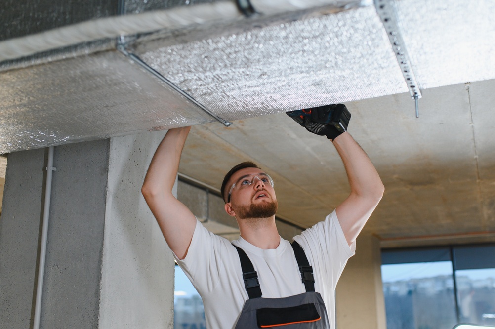 Technician inspecting a commercial air duct system that needs immediate cleaning and maintenance