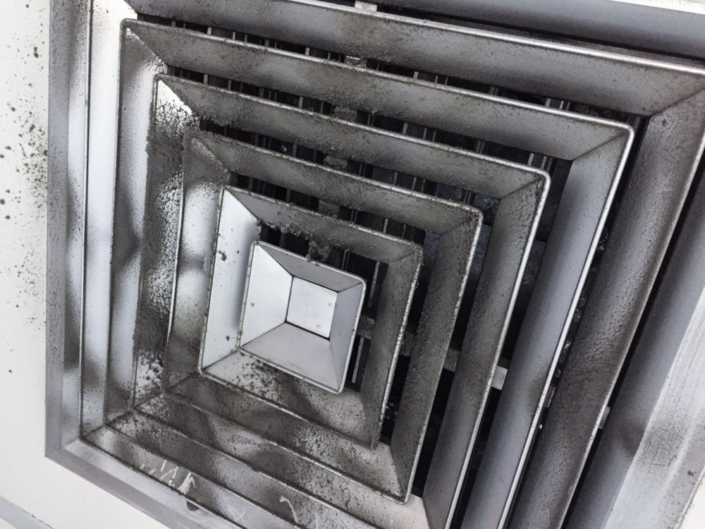 Technician performing professional air duct cleaning services to improve workplace safety and air quality
