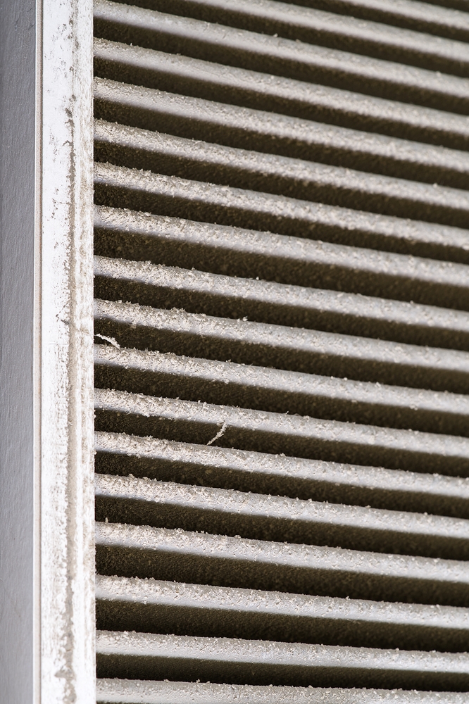 HVAC technician inspecting dirty home air ducts linked to morning allergy symptoms